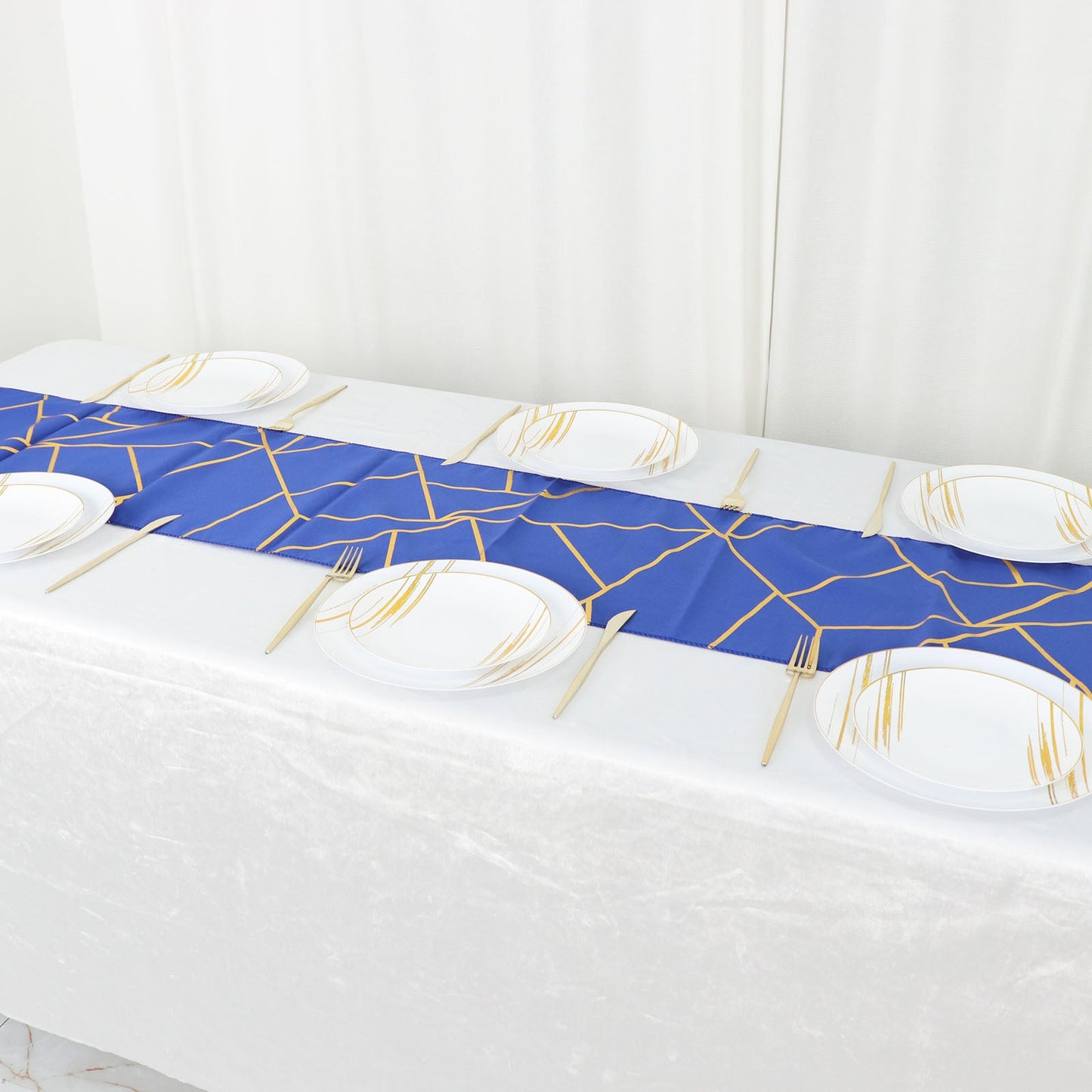 9ft royal blue table runner with gold foil geometric pattern on a white table.
