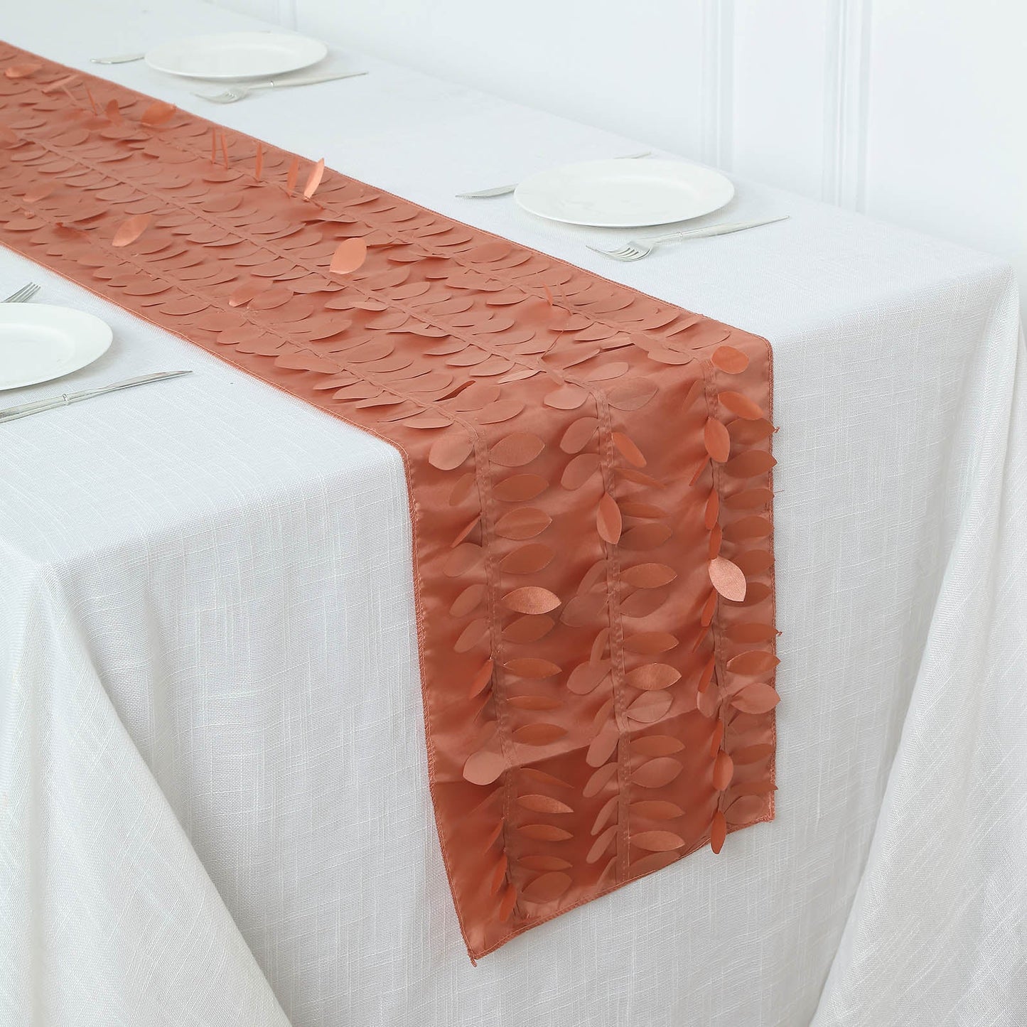 Terracotta 3D leaf petal taffeta fabric table runner on a white tablecloth.