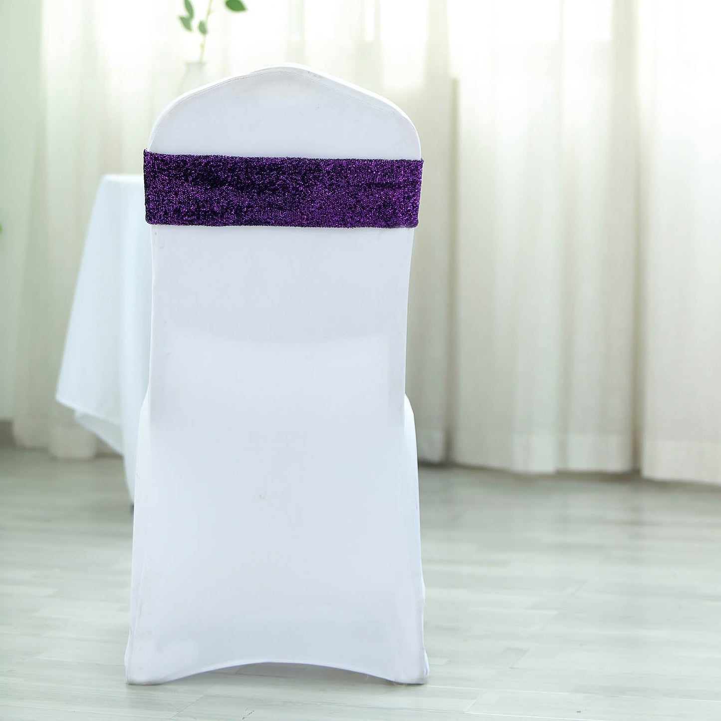 Purple metallic shimmer tinsel spandex chair sash on a white chair.