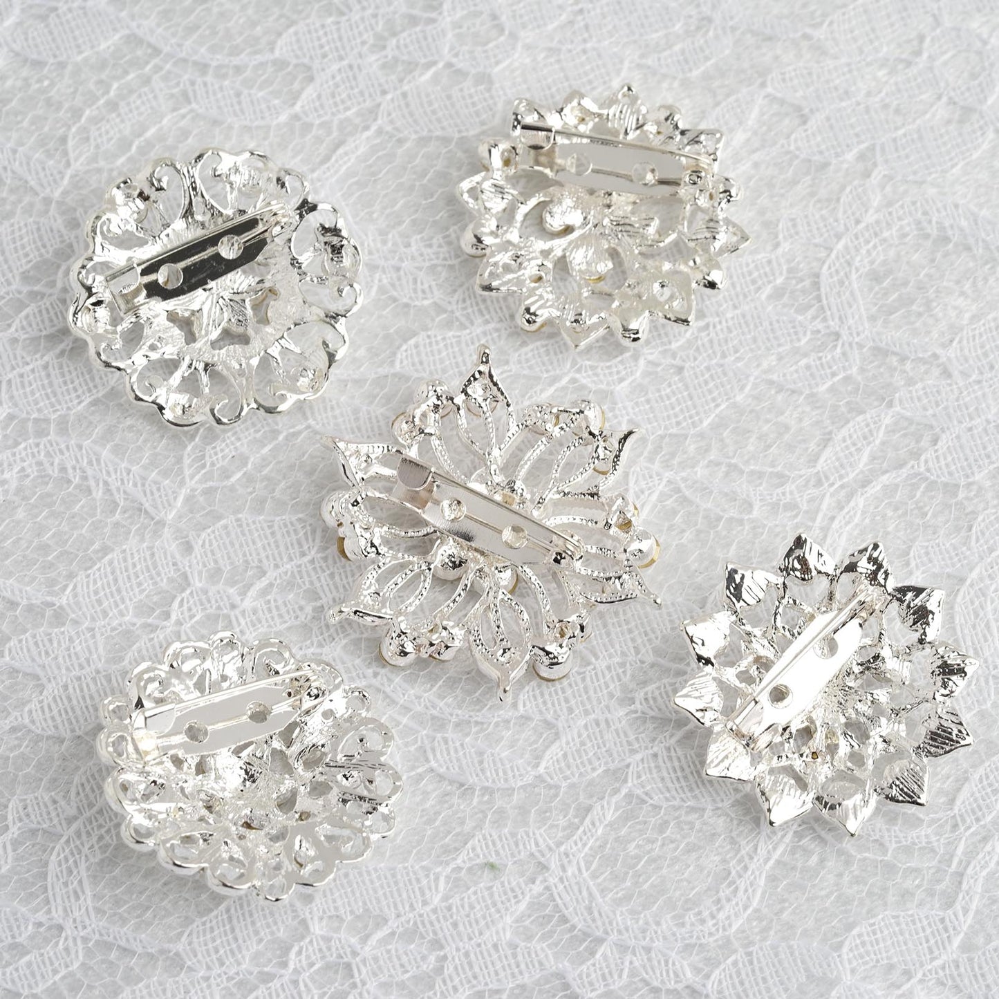 Assorted silver plated mandala brooches with crystal rhinestones.
