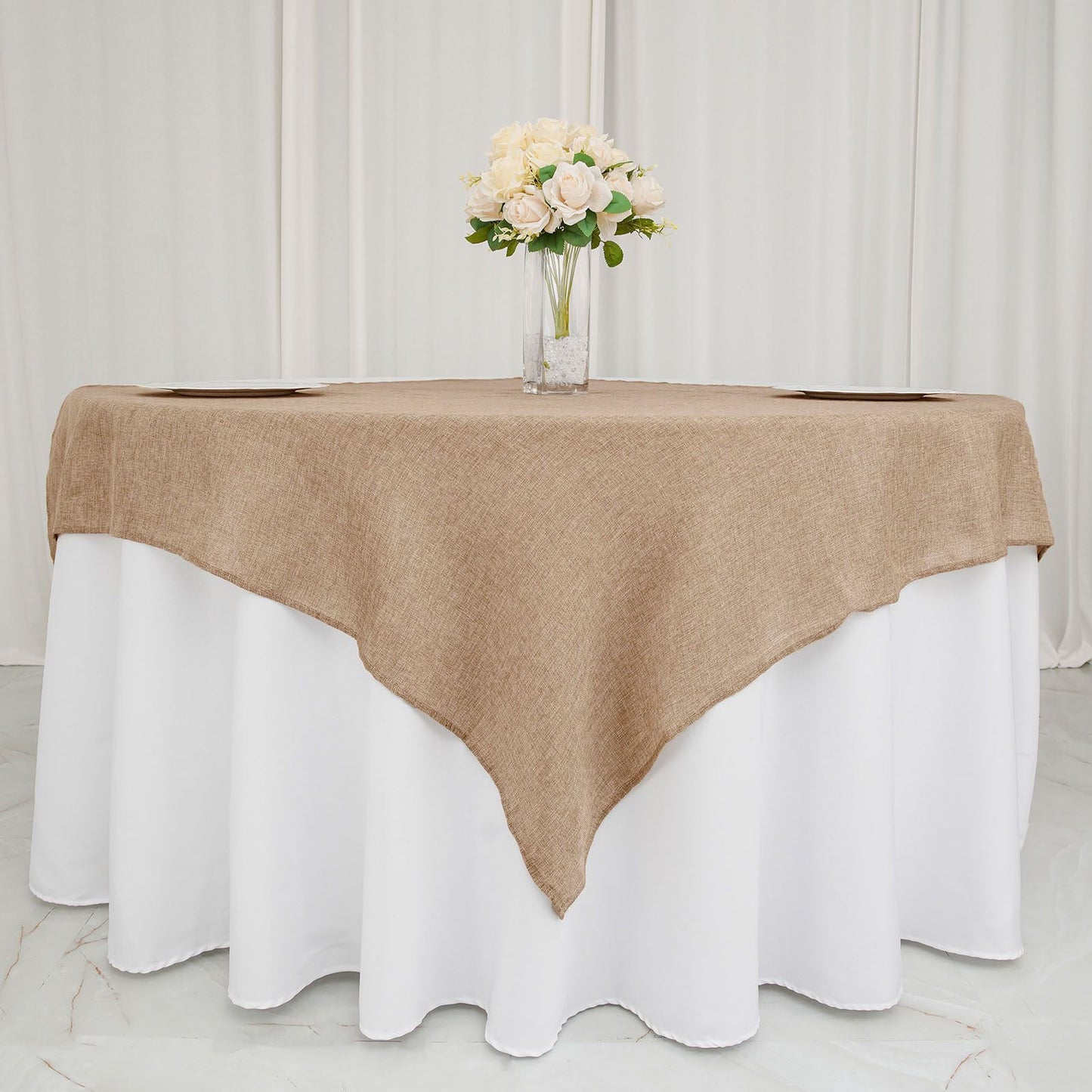 Natural faux burlap square table overlay on a white tablecloth.