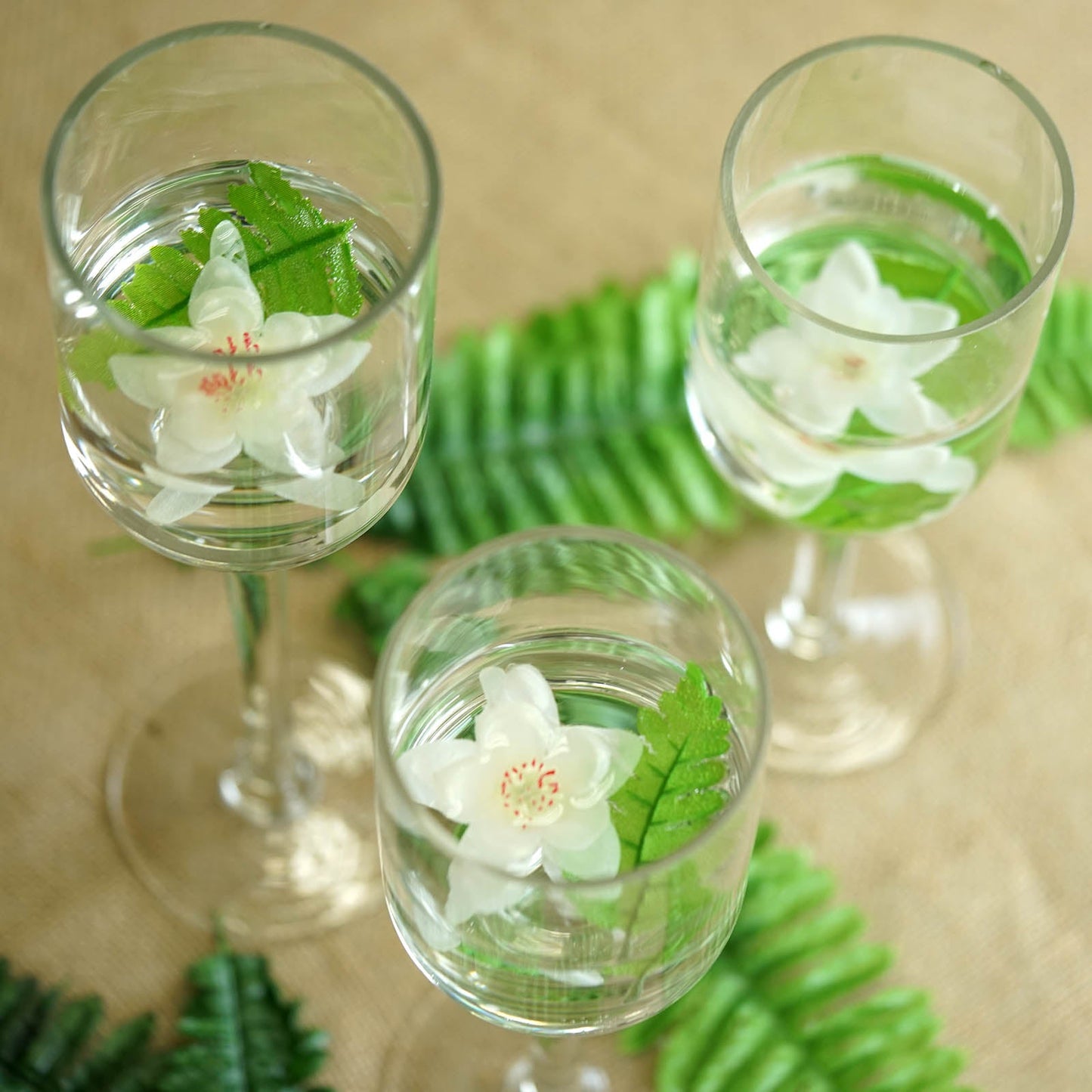 Clear long stem cylinder glass vase candle holder set with floral decor.