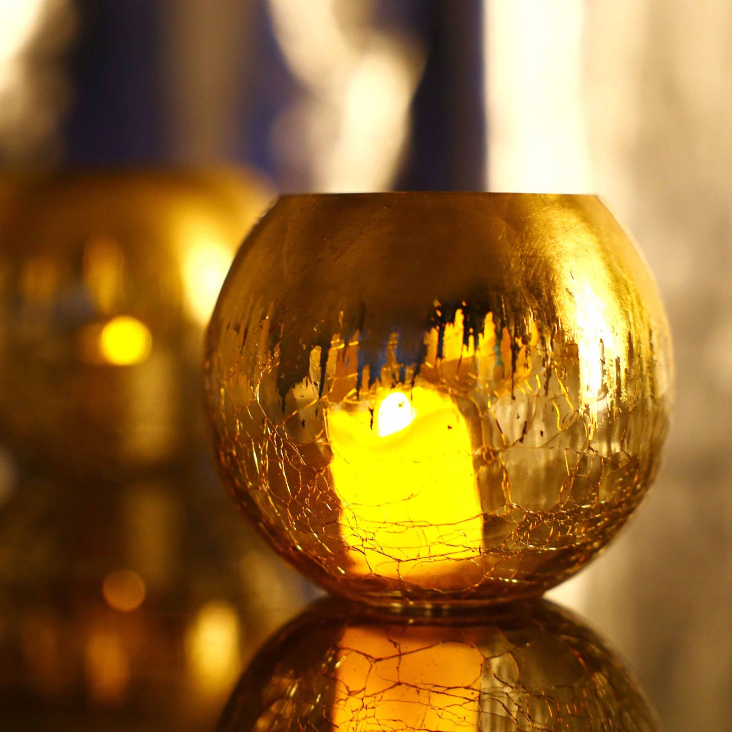 Gold foiled crackle glass bud vase centerpiece with warm glow.