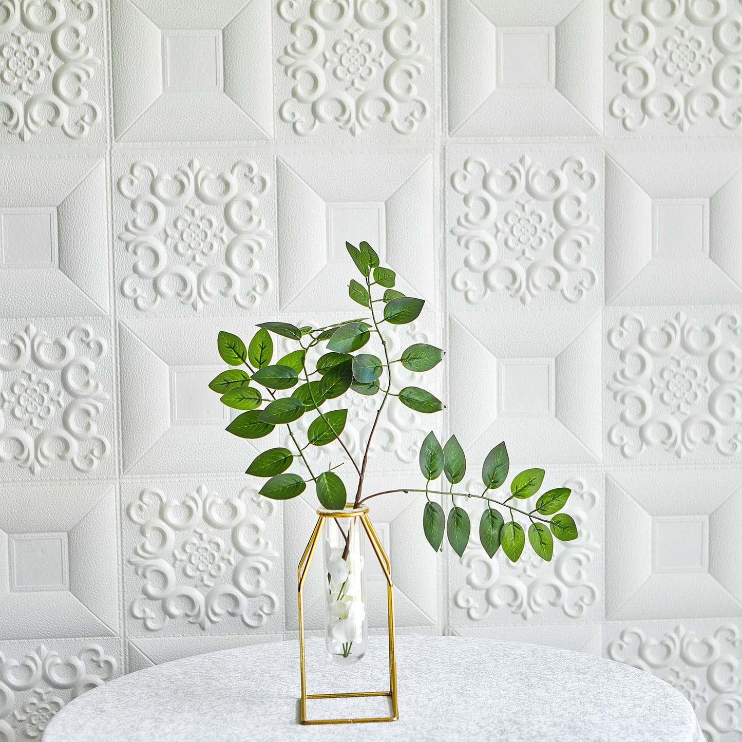 White 3D foam wall panels with French design and decorative greenery.