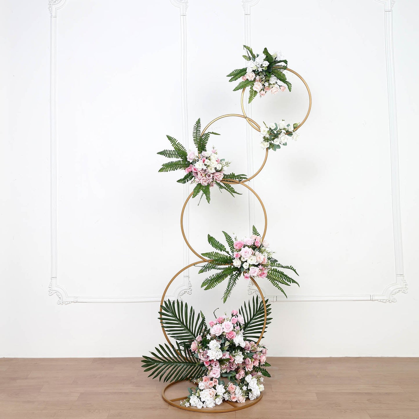 Gold hoop pillar flower stand with floral arrangements.