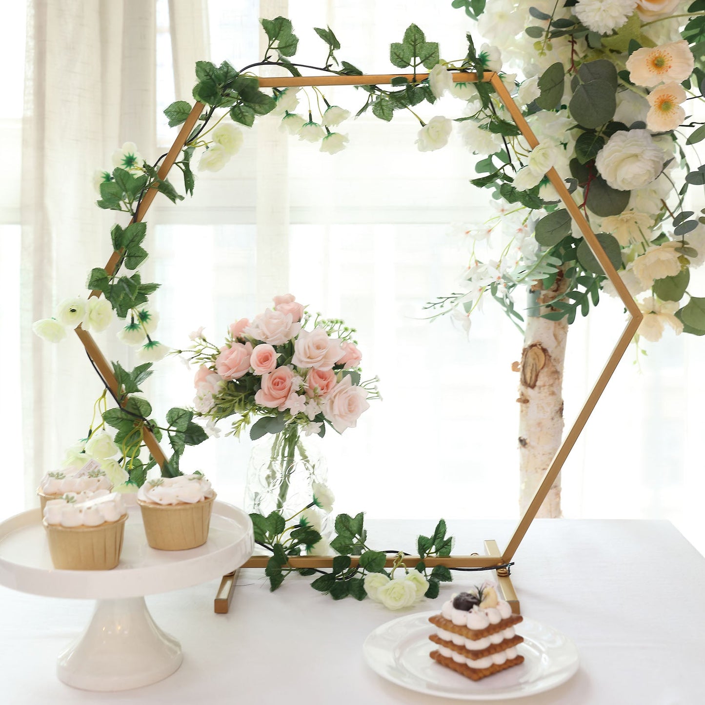 Gold metal hexagon wedding arch centerpiece with floral decor.