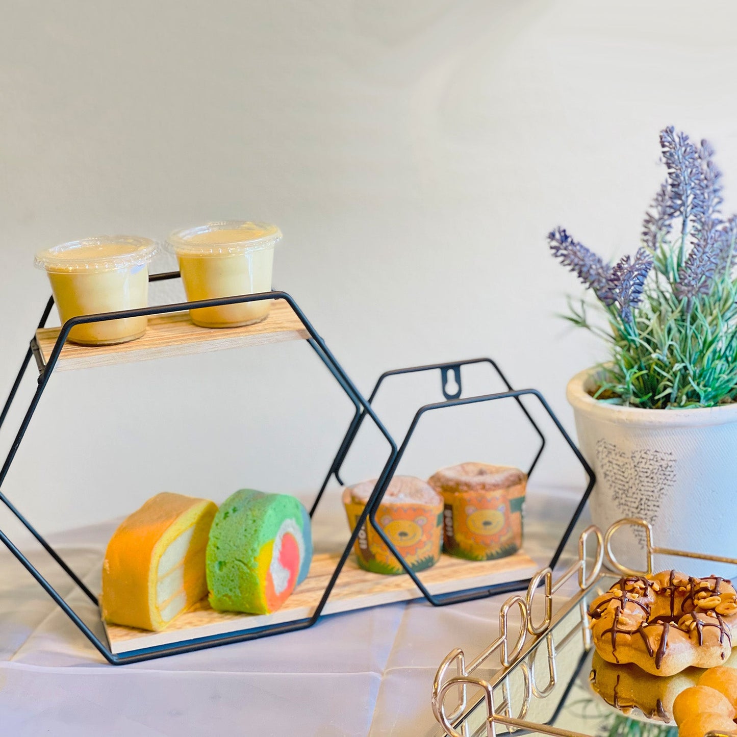 Black geometric floating shelf displaying colorful desserts and drinks.