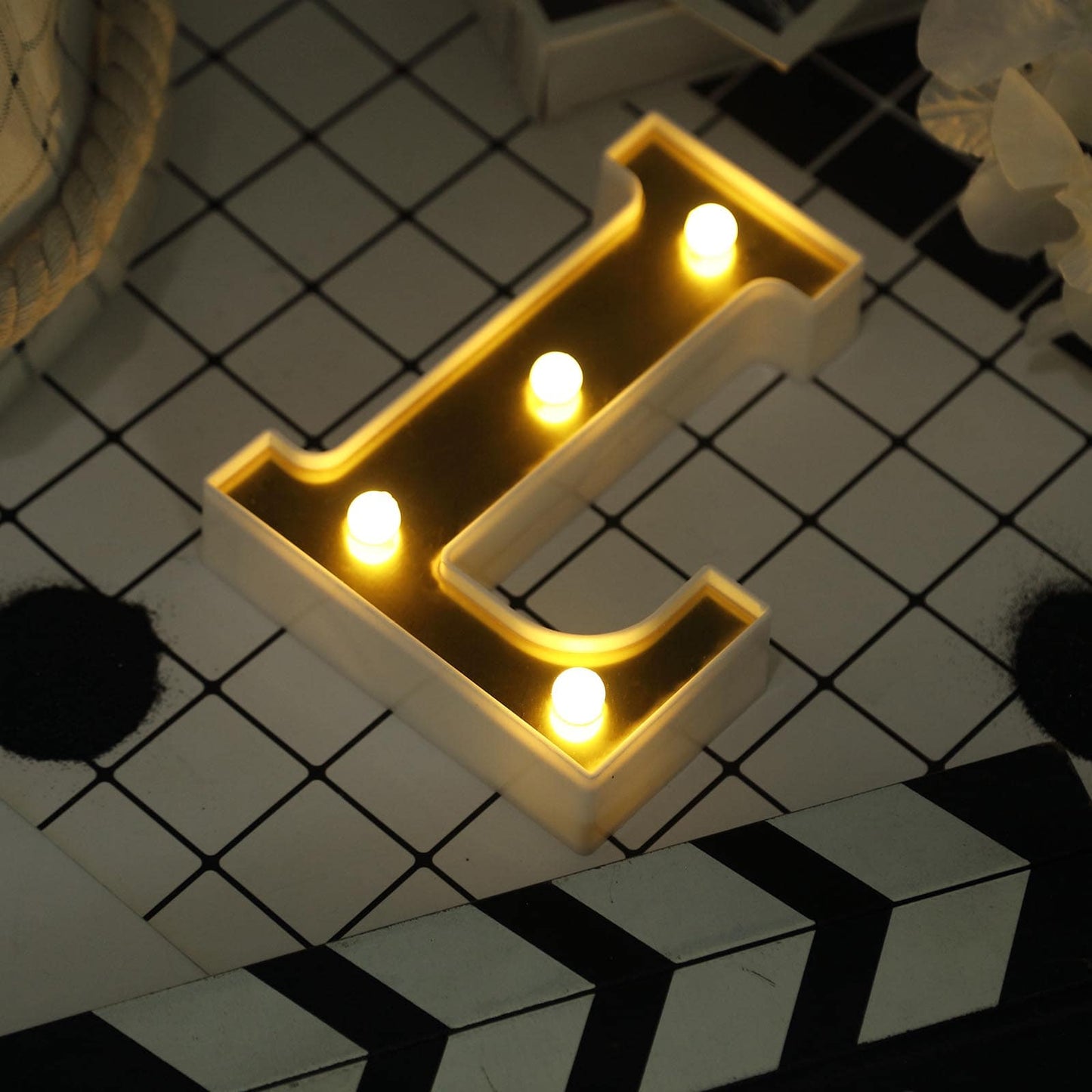 Gold 3D marquee letter "L" with warm white LED lights.