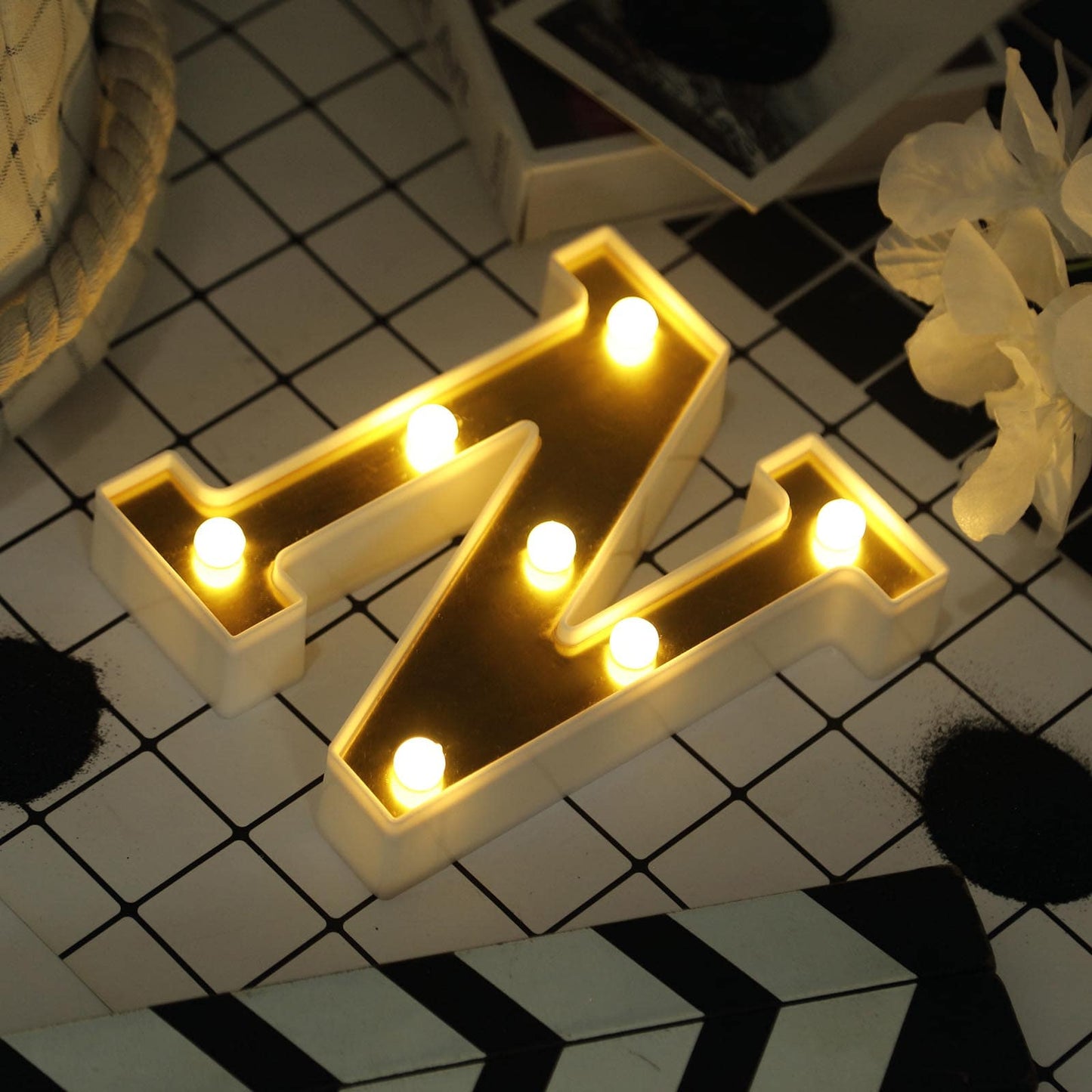 Gold 3D marquee letter "N" with warm white LED lights.