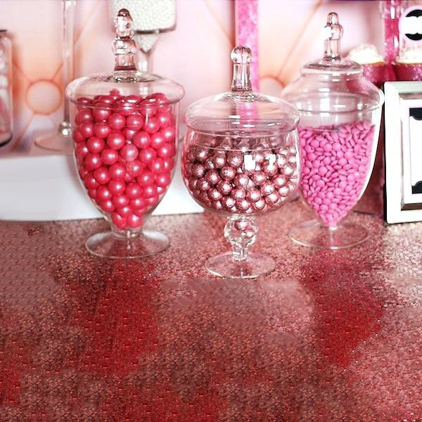 Clear apothecary glass jars with snap on lids, filled with pink candies.
