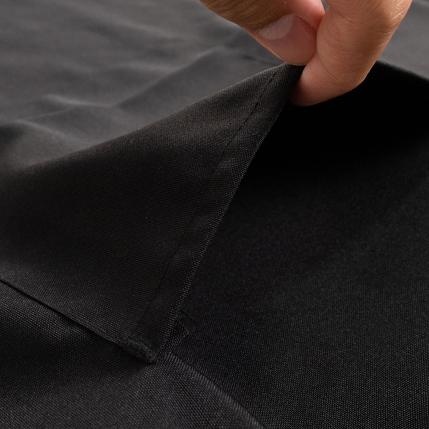 Black premium polyester chef apron with adjustable neck and long ties.