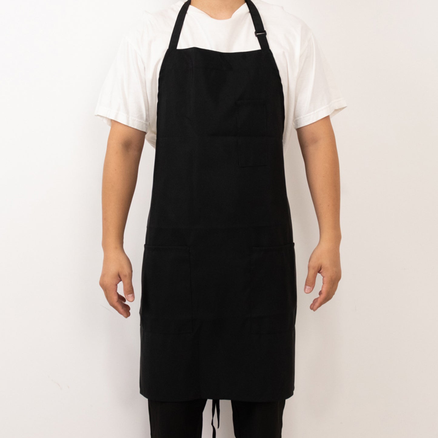 Black cooking chef apron with adjustable neck and pockets.