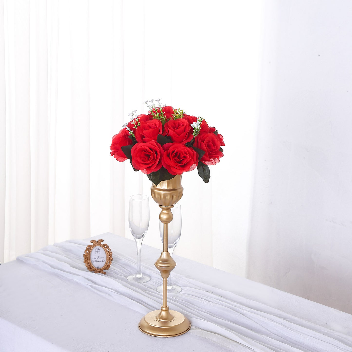 Red silk rose flower ball centerpiece arrangement on a gold stand.