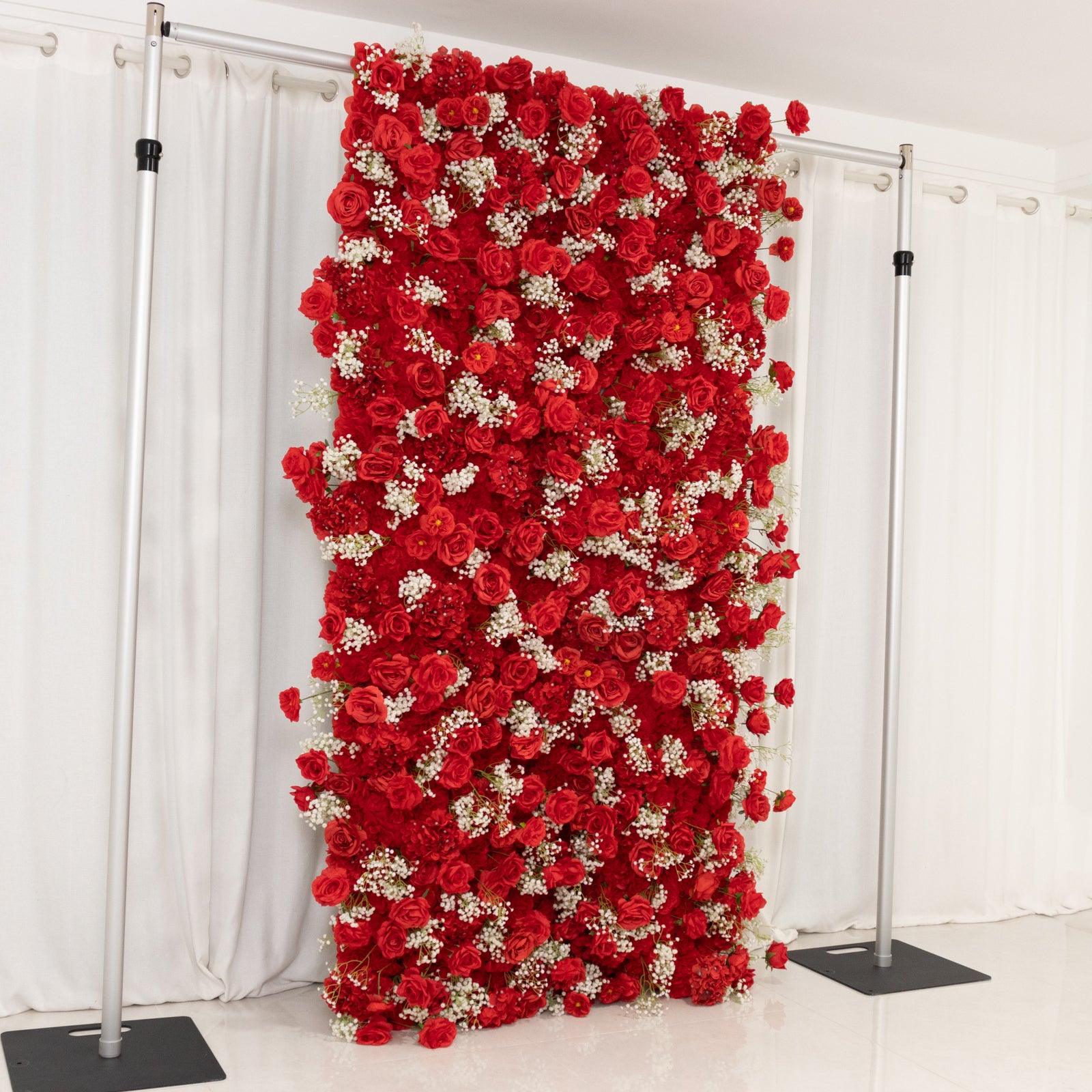Red artificial flower wall panel backdrop with silk roses and baby's breath.