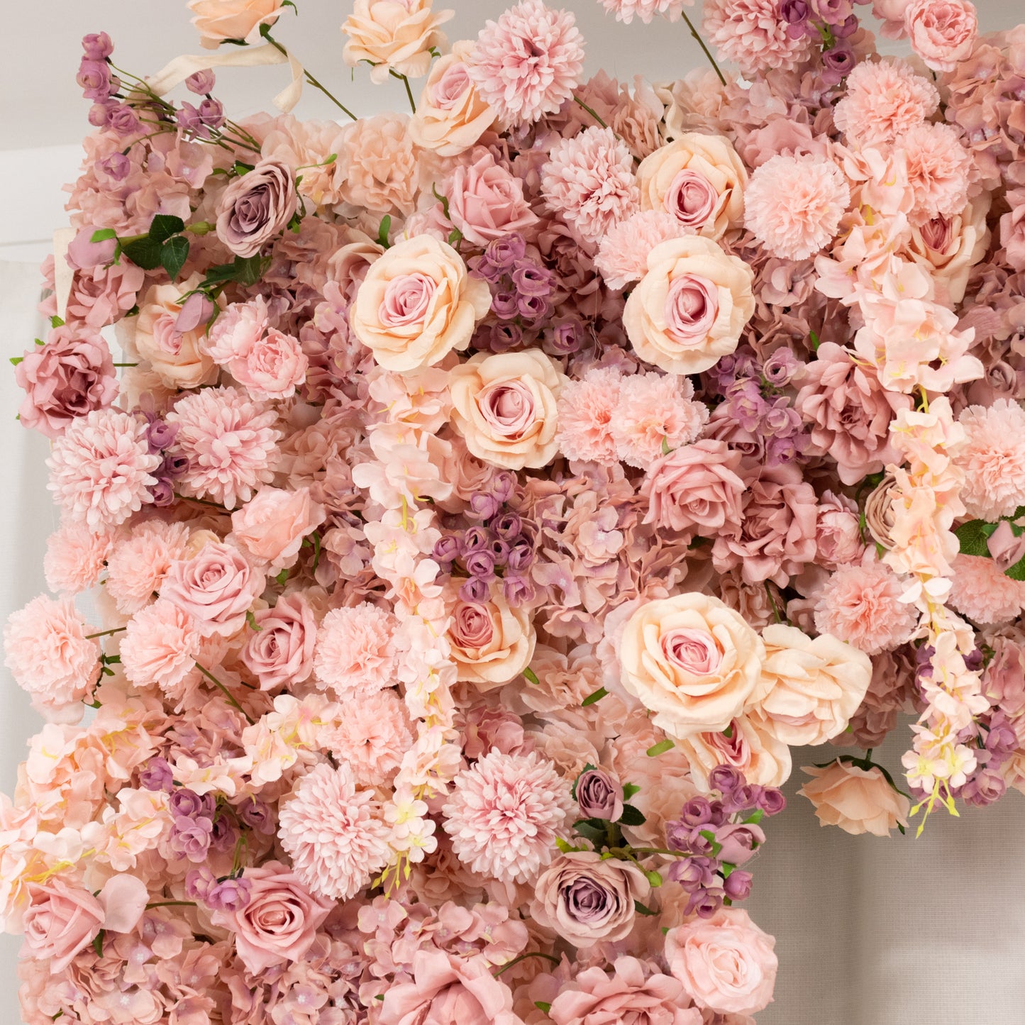 Dusty rose flower backdrop with artificial silk roses and hydrangeas.