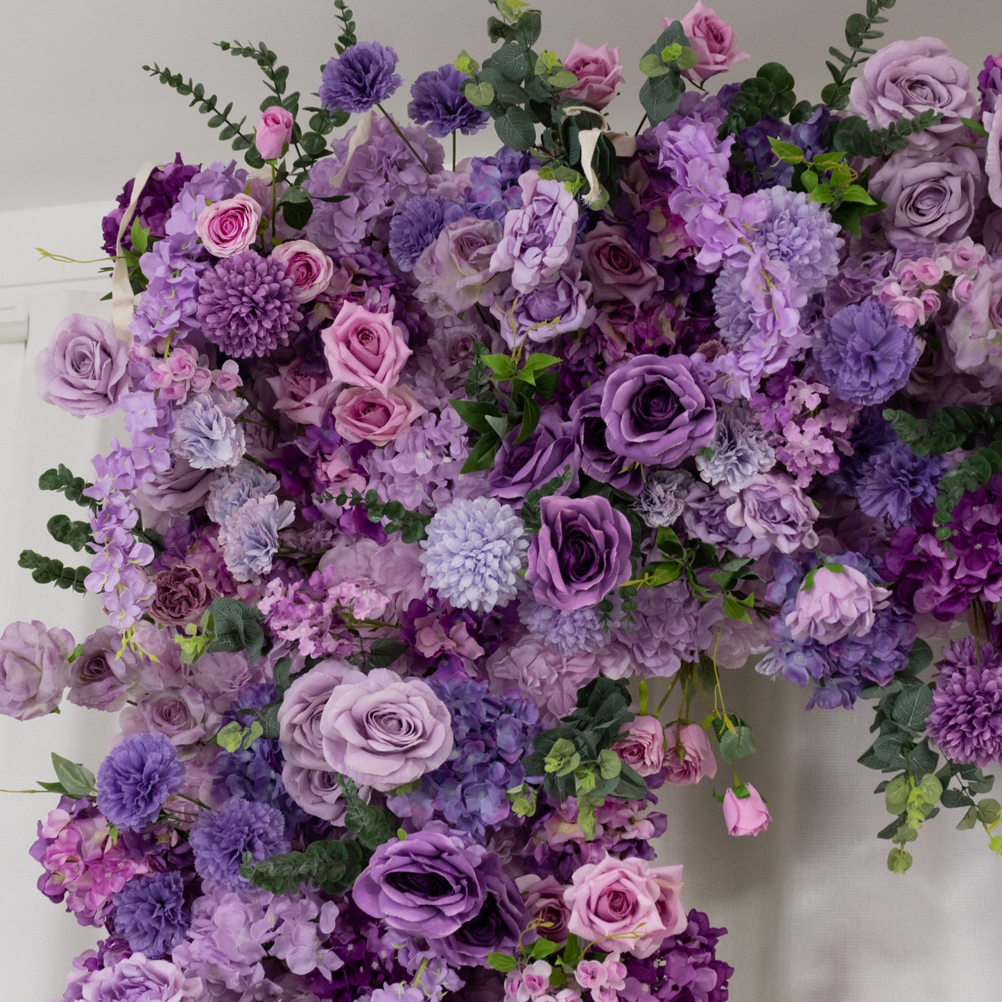 Lavender lilac flower backdrop with artificial silk roses and hydrangeas.