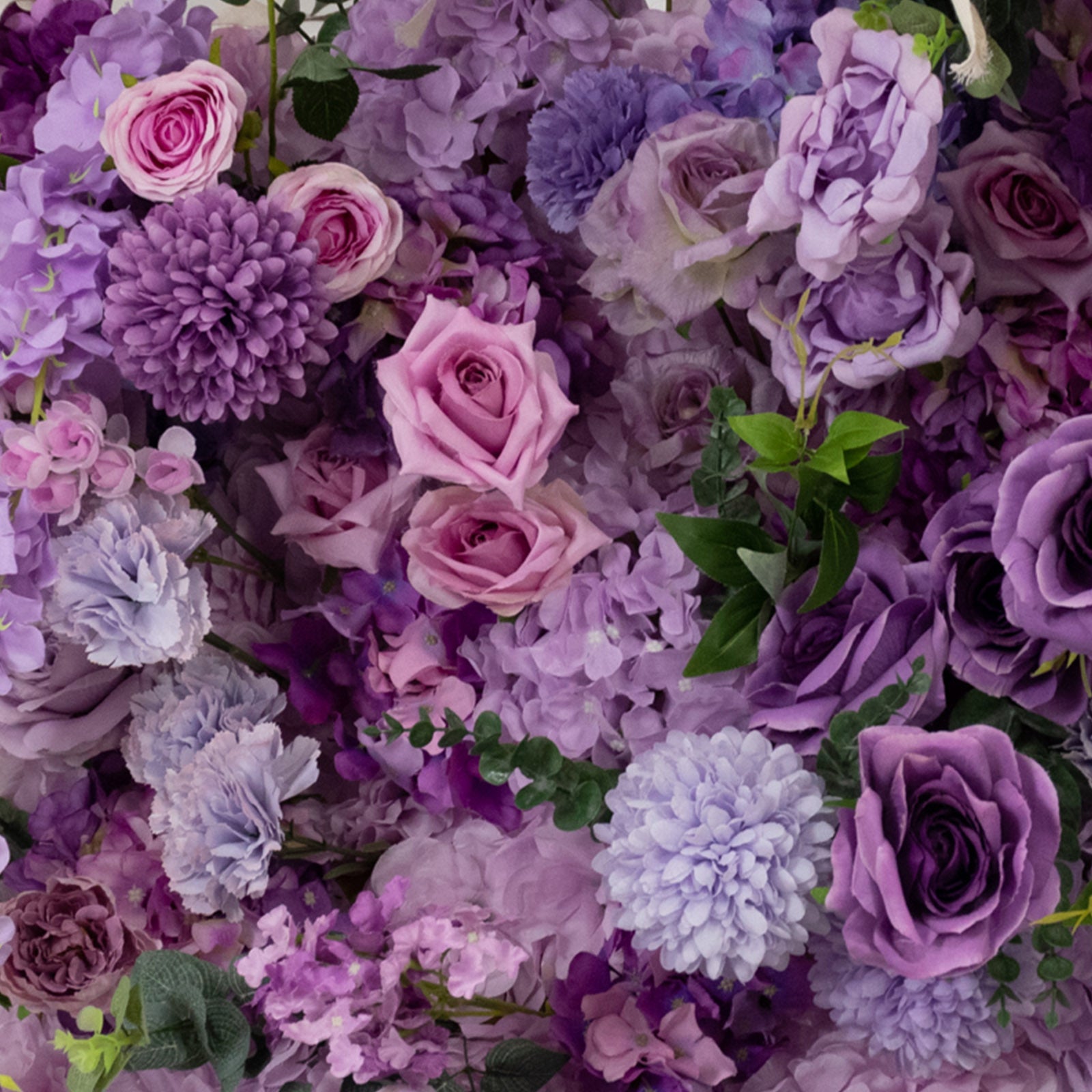 Lavender floral backdrop with artificial silk roses and hydrangeas.
