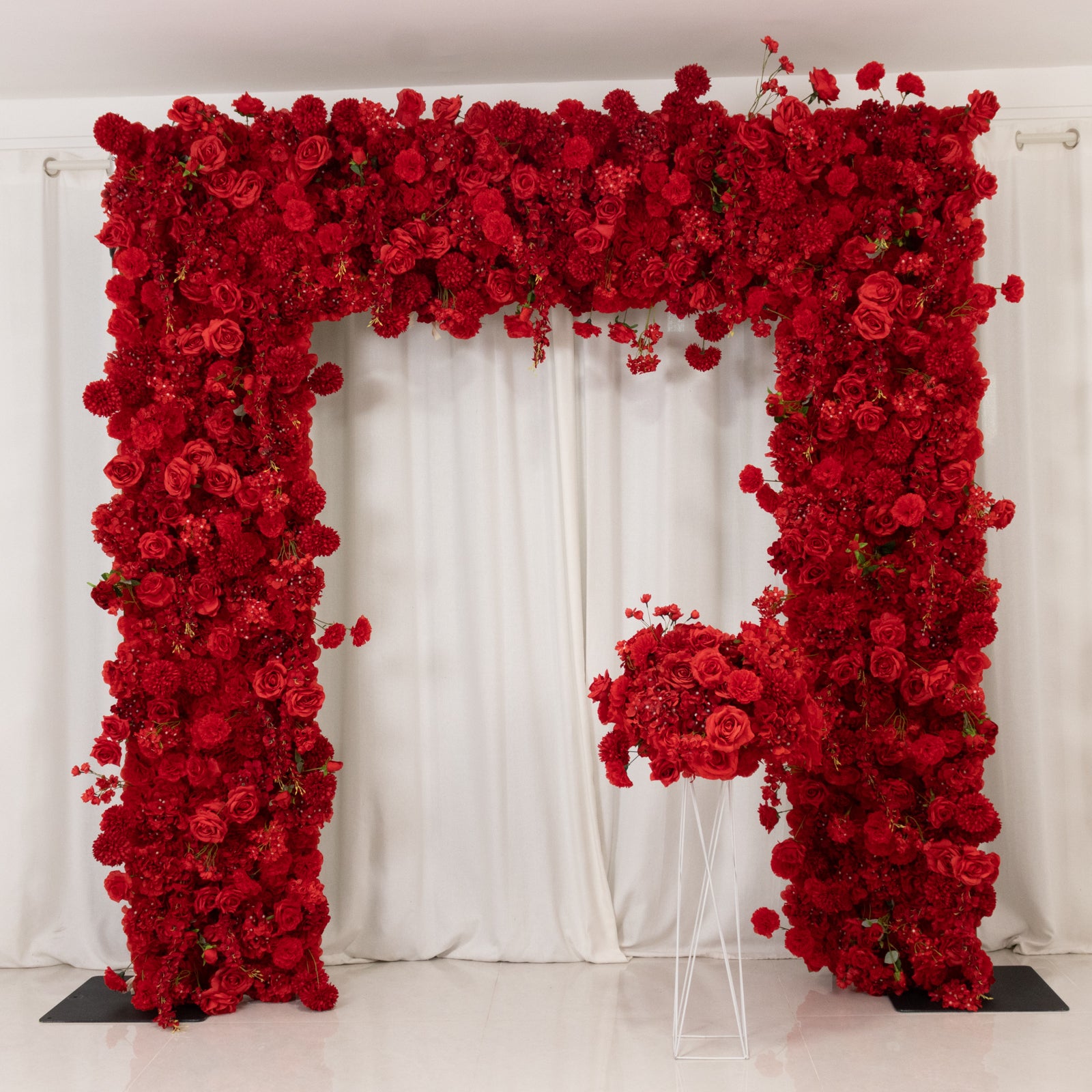 Red floral backdrop with artificial roses and hydrangeas for weddings.