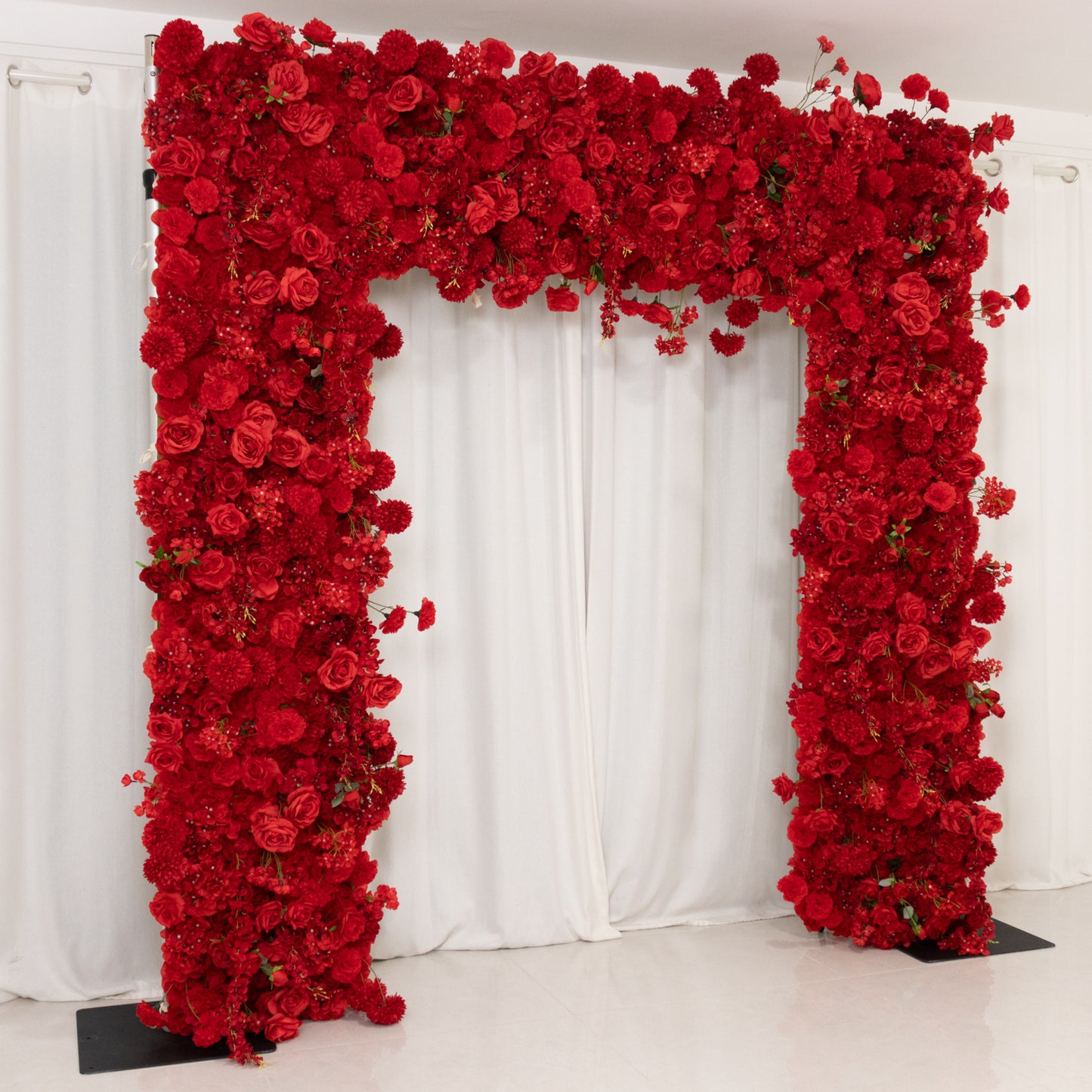 Red floral arch backdrop with artificial roses and hydrangeas for weddings.