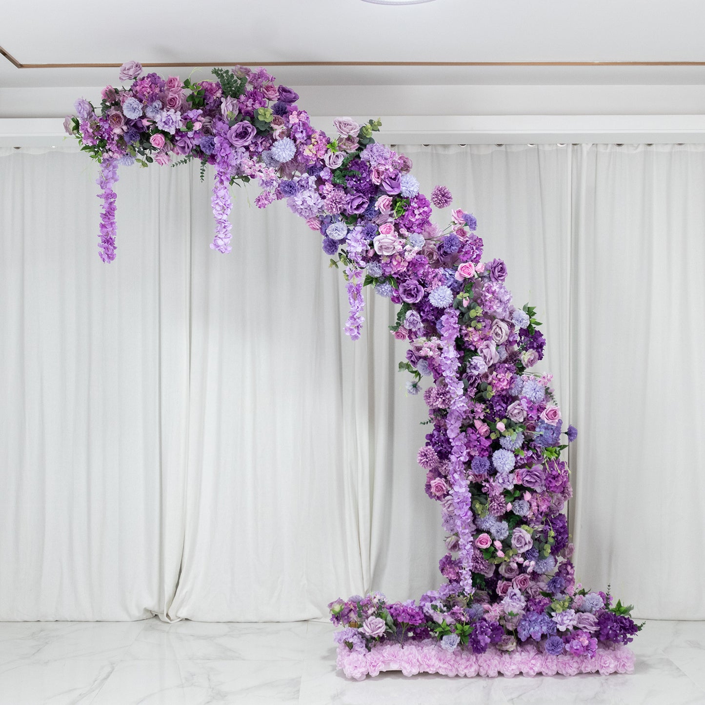 Lavender floral backdrop arch with roses, hydrangeas, and chrysanthemums.