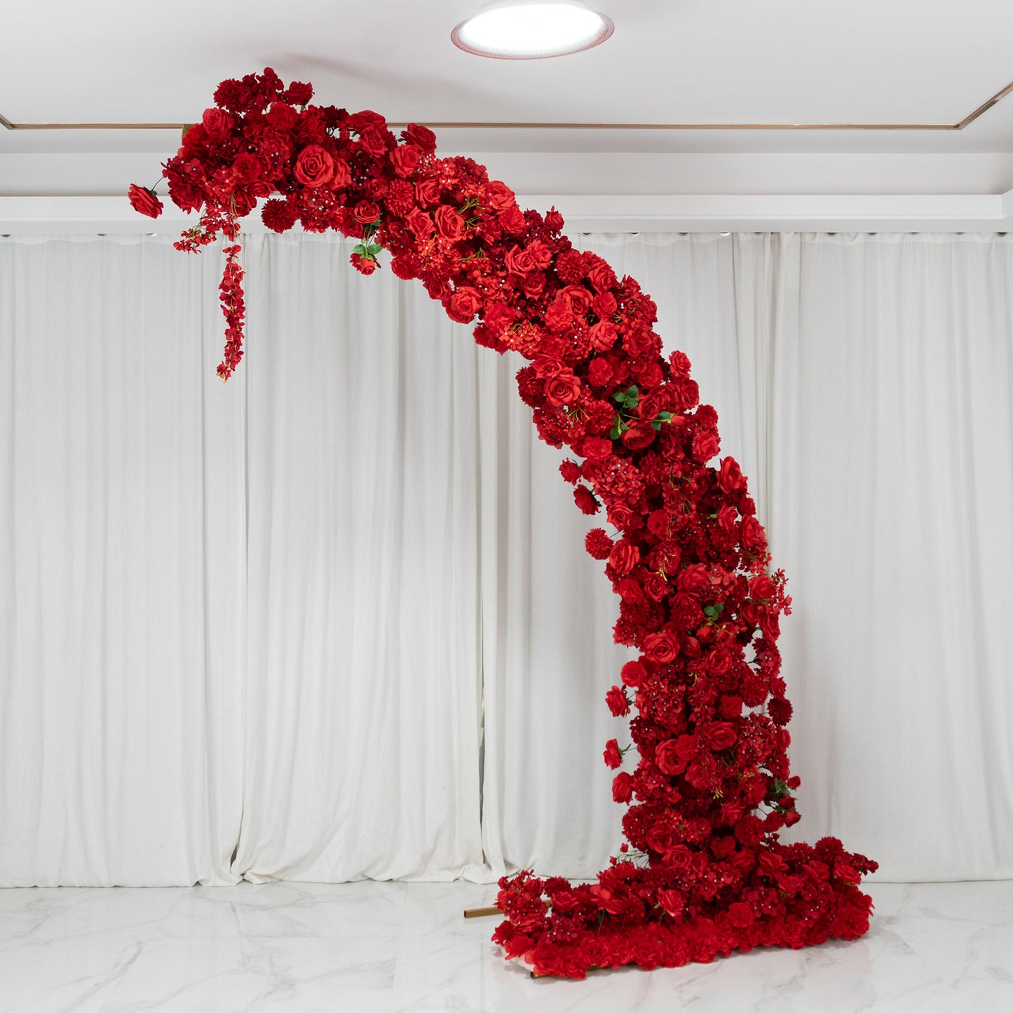Red floral backdrop for wedding arch with roses, hydrangeas, and chrysanthemums.