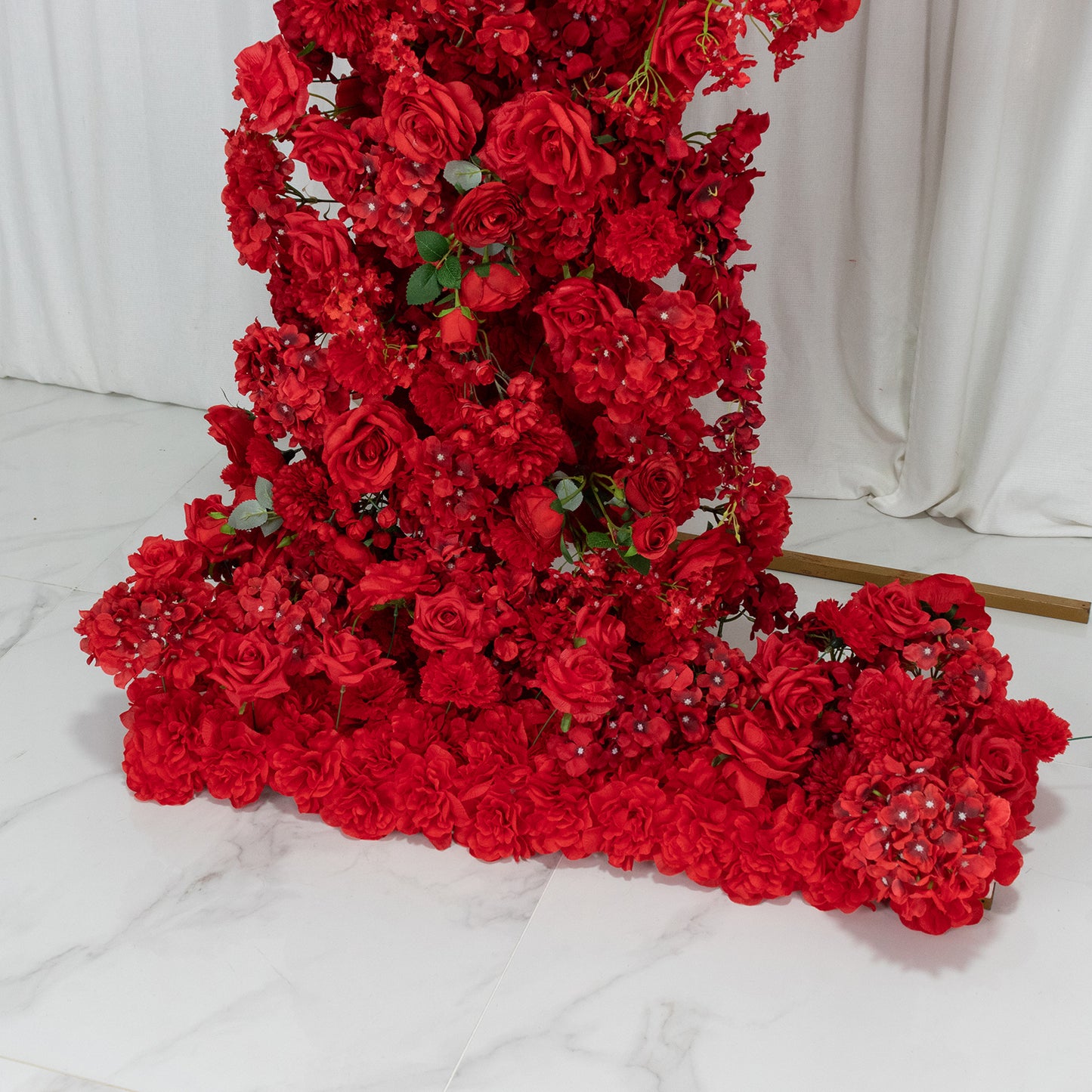 Red artificial silk floral backdrop for a wedding arch with roses and hydrangeas.