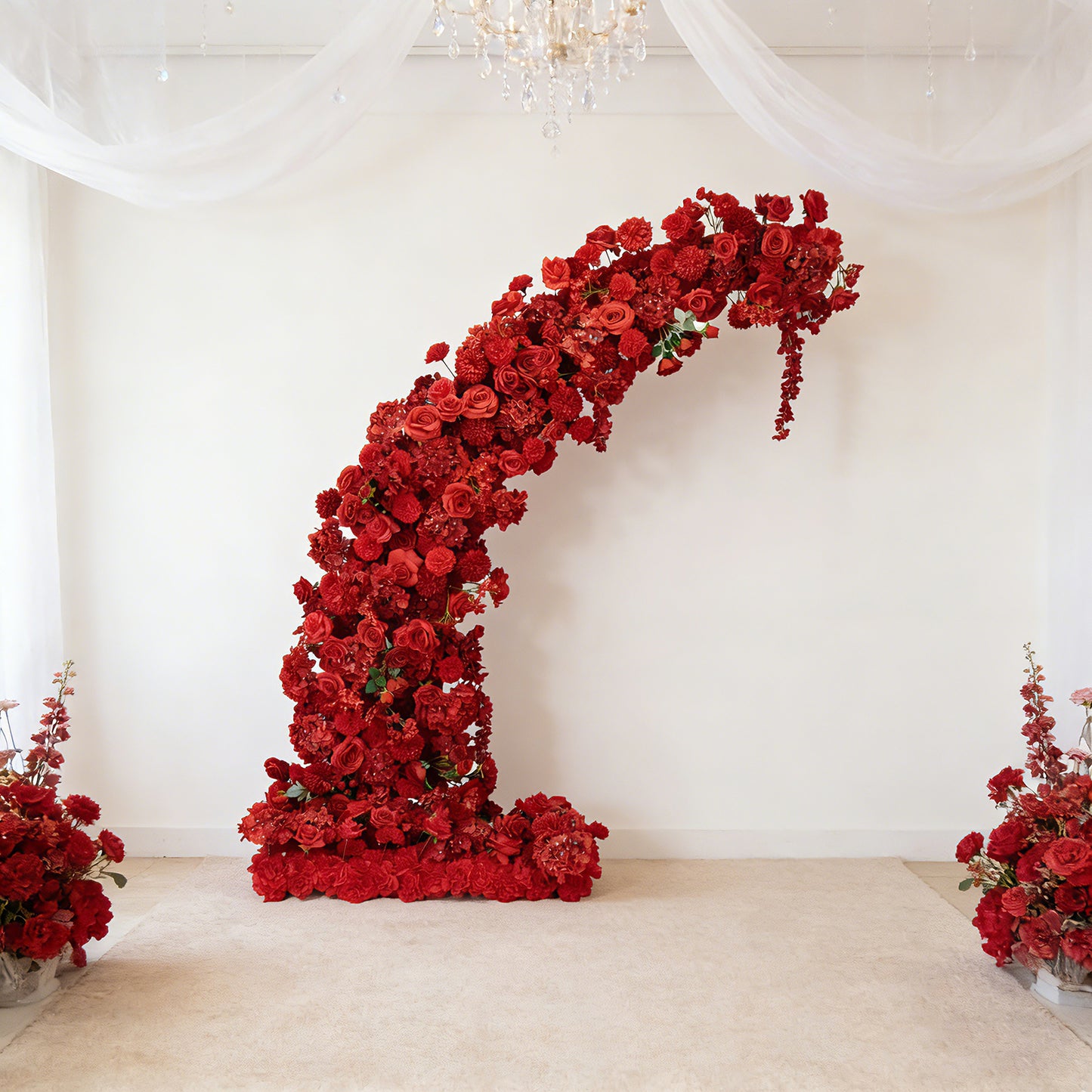 Red floral backdrop for a half crescent wedding arch with roses and hydrangeas.