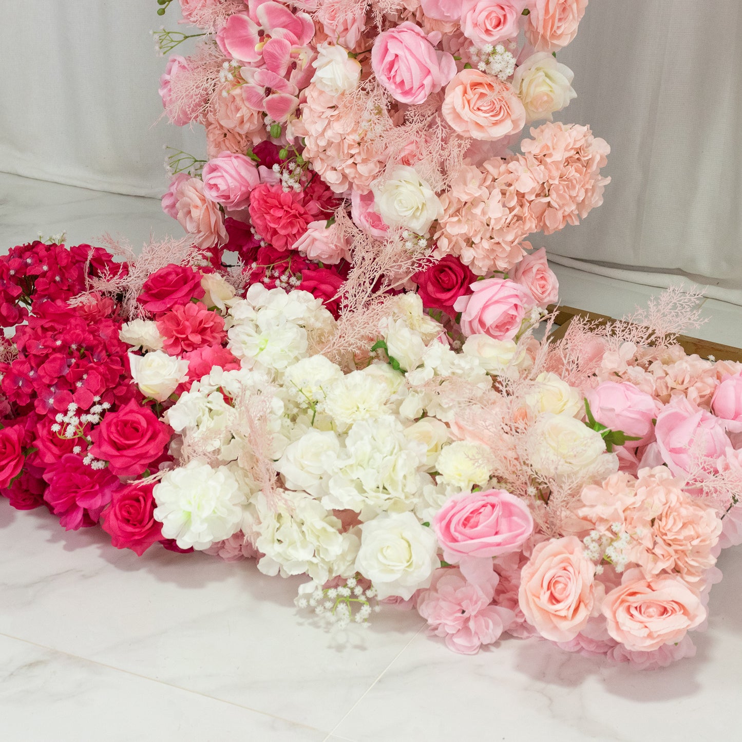 White and pink floral backdrop for wedding arch with assorted flowers.