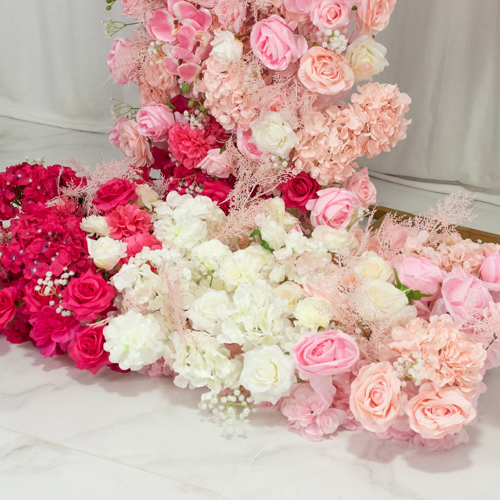 White and pink floral backdrop for wedding arch with assorted flowers.