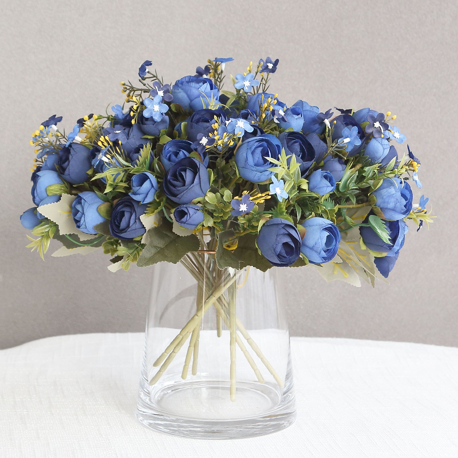 Navy blue artificial ranunculus silk flower bridal bouquets in a vase.