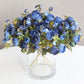 Navy blue artificial ranunculus flower bouquet in a glass vase.