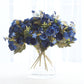 Navy blue artificial ranunculus flower bouquet in a clear vase.