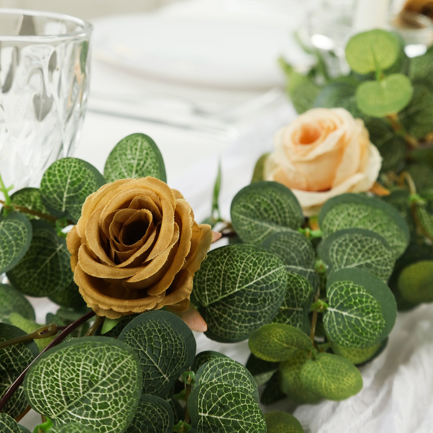 Cream and gold artificial eucalyptus garland with silk roses.