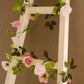 Blush dusty rose artificial silk flower garland on a ladder.