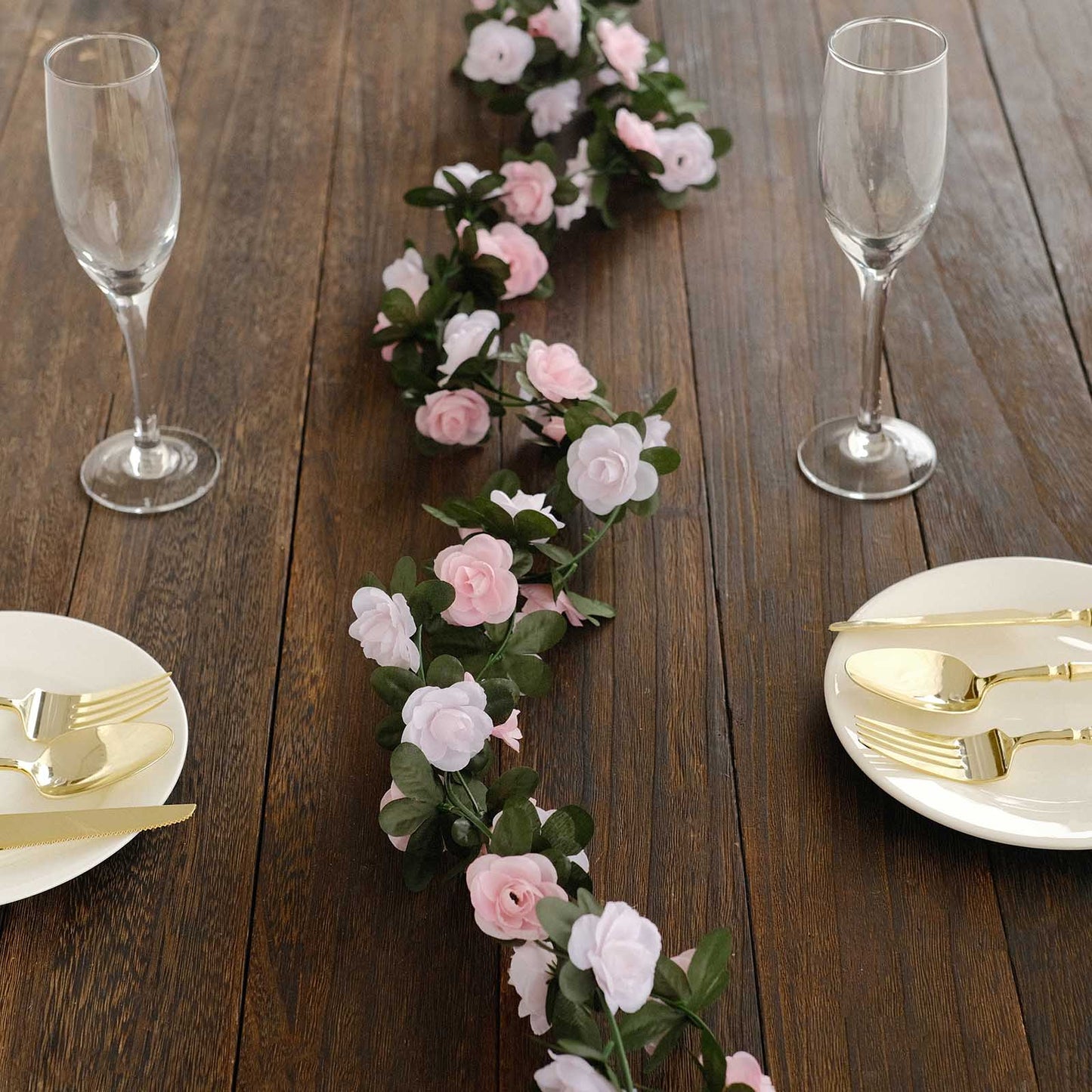 Blush dusty rose artificial silk flower garland on a wooden table.
