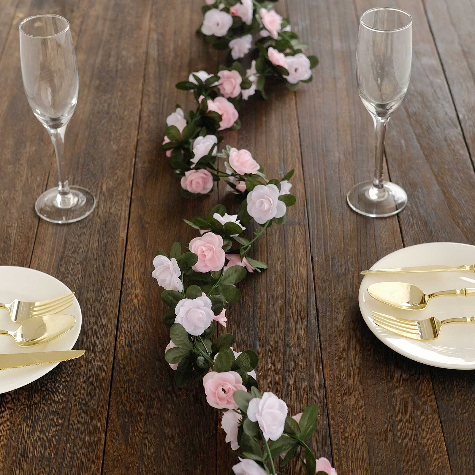 Blush dusty rose artificial silk flower garland on a wooden table.