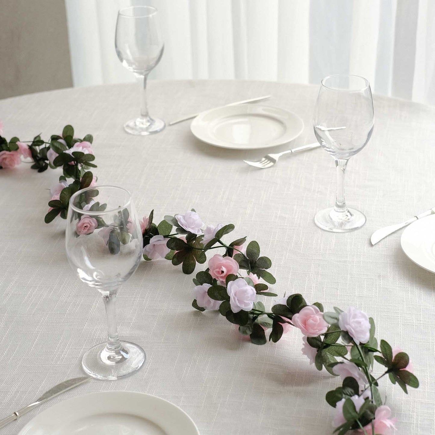 Blush dusty rose artificial silk flower garland on a table setting.