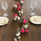 Blush fuchsia silk flower garland with mini roses on a dining table.