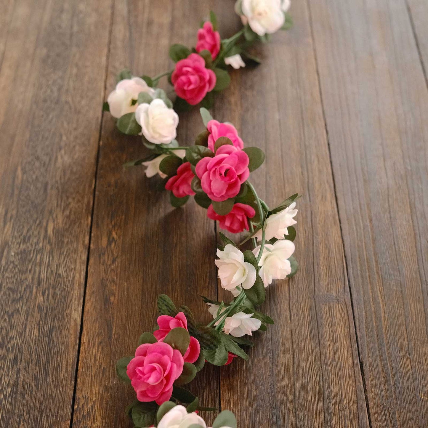 Blush fuchsia artificial silk flower garland with rose vines and flower heads.