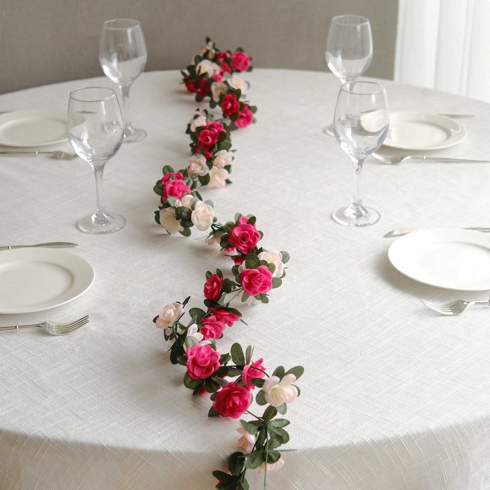Blush fuchsia artificial silk flower garland on a dining table.