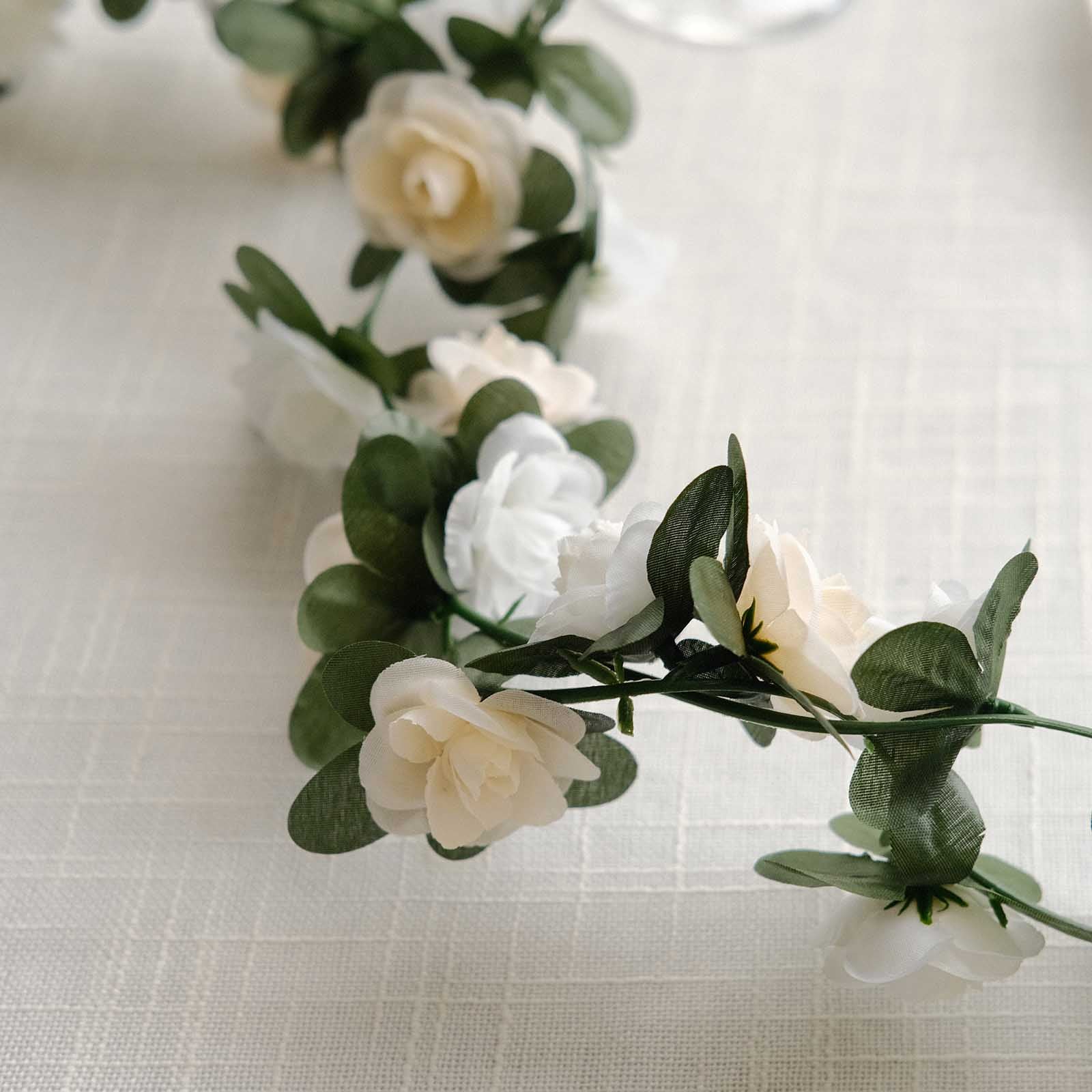 Cream ivory artificial silk flower garland with mini rose vines and green leaves.