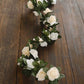 Cream ivory artificial silk flower garland with mini rose vines and green leaves.
