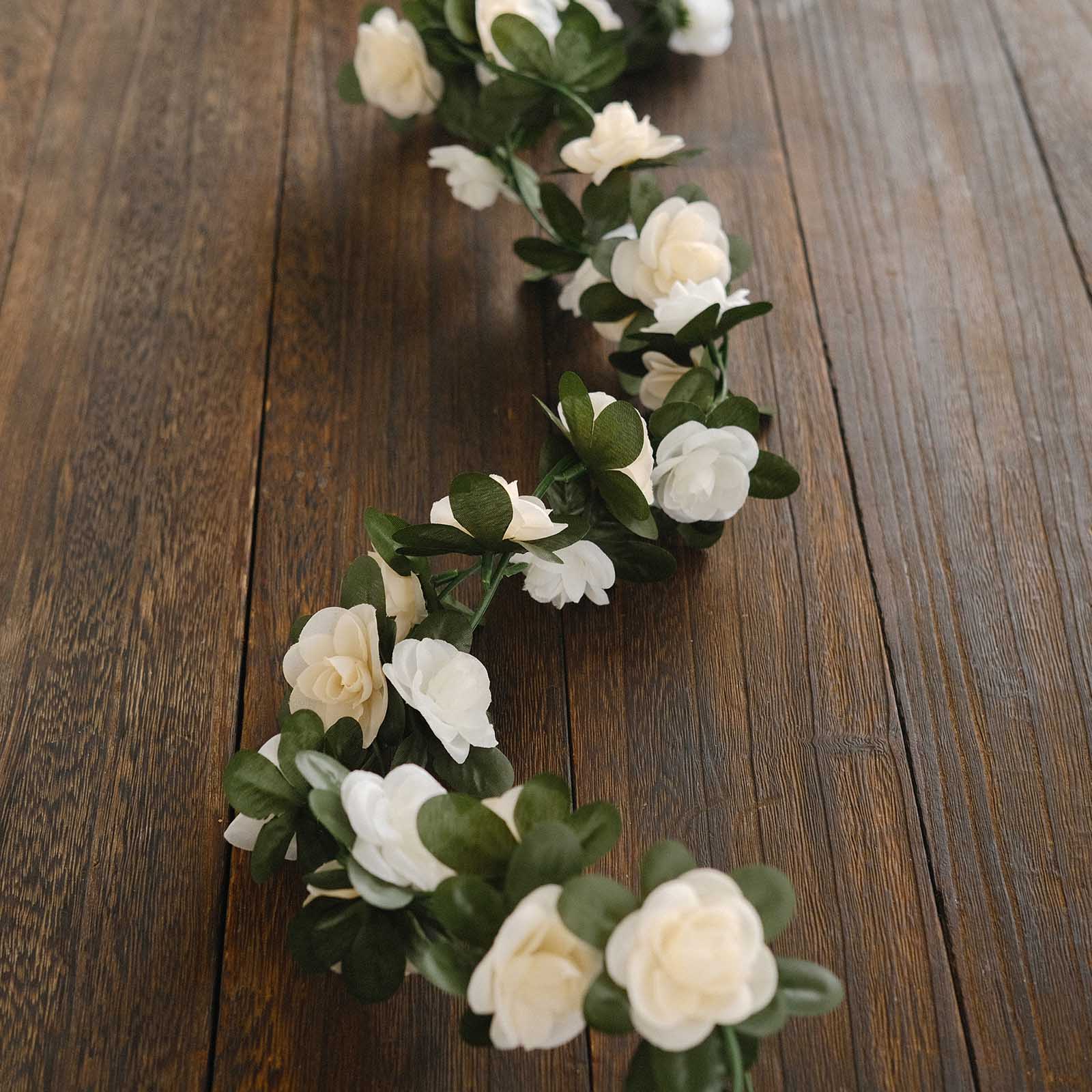 Cream ivory artificial silk flower garland with mini rose vines and green leaves.