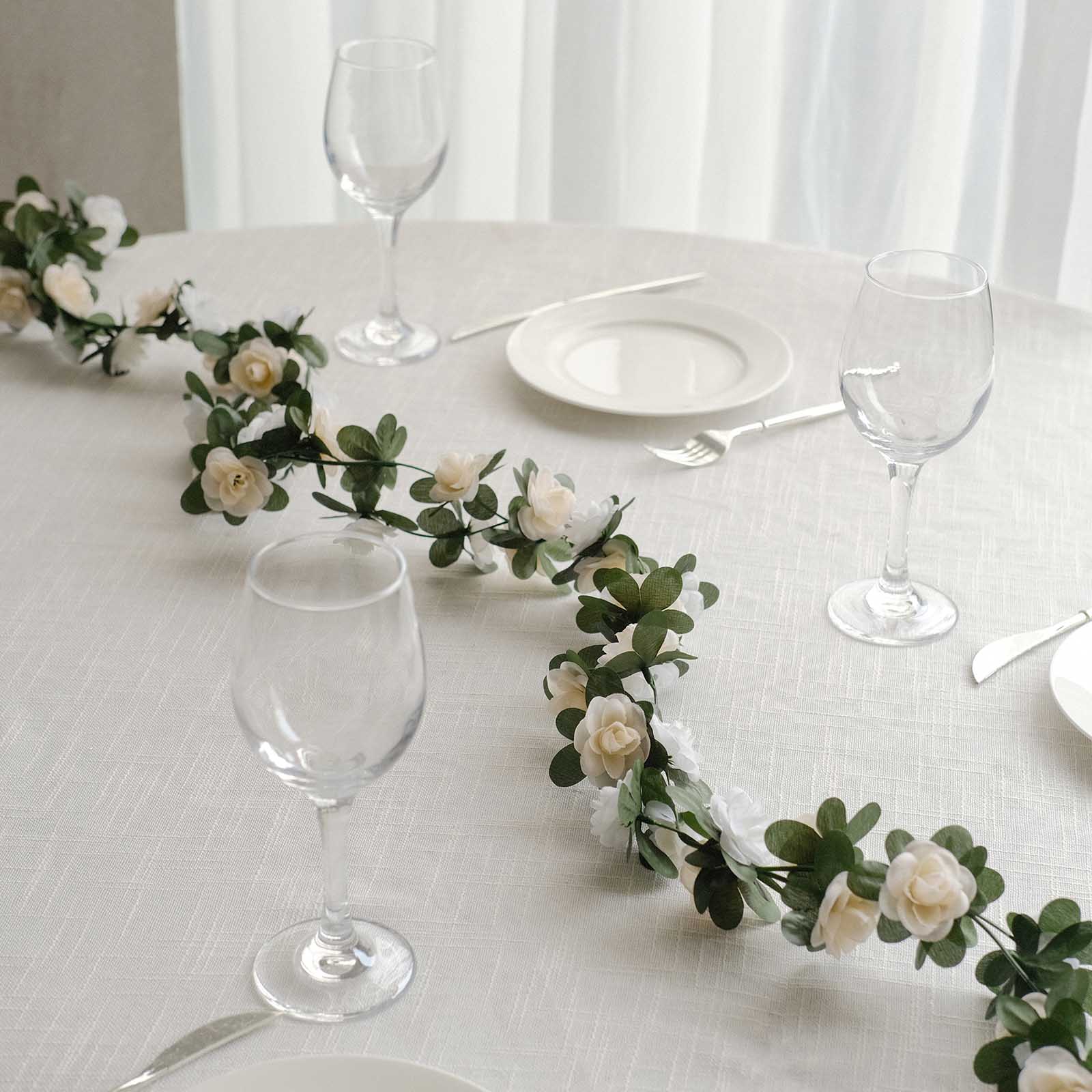 Cream ivory artificial silk rose garland with mini flowers on a table setting.