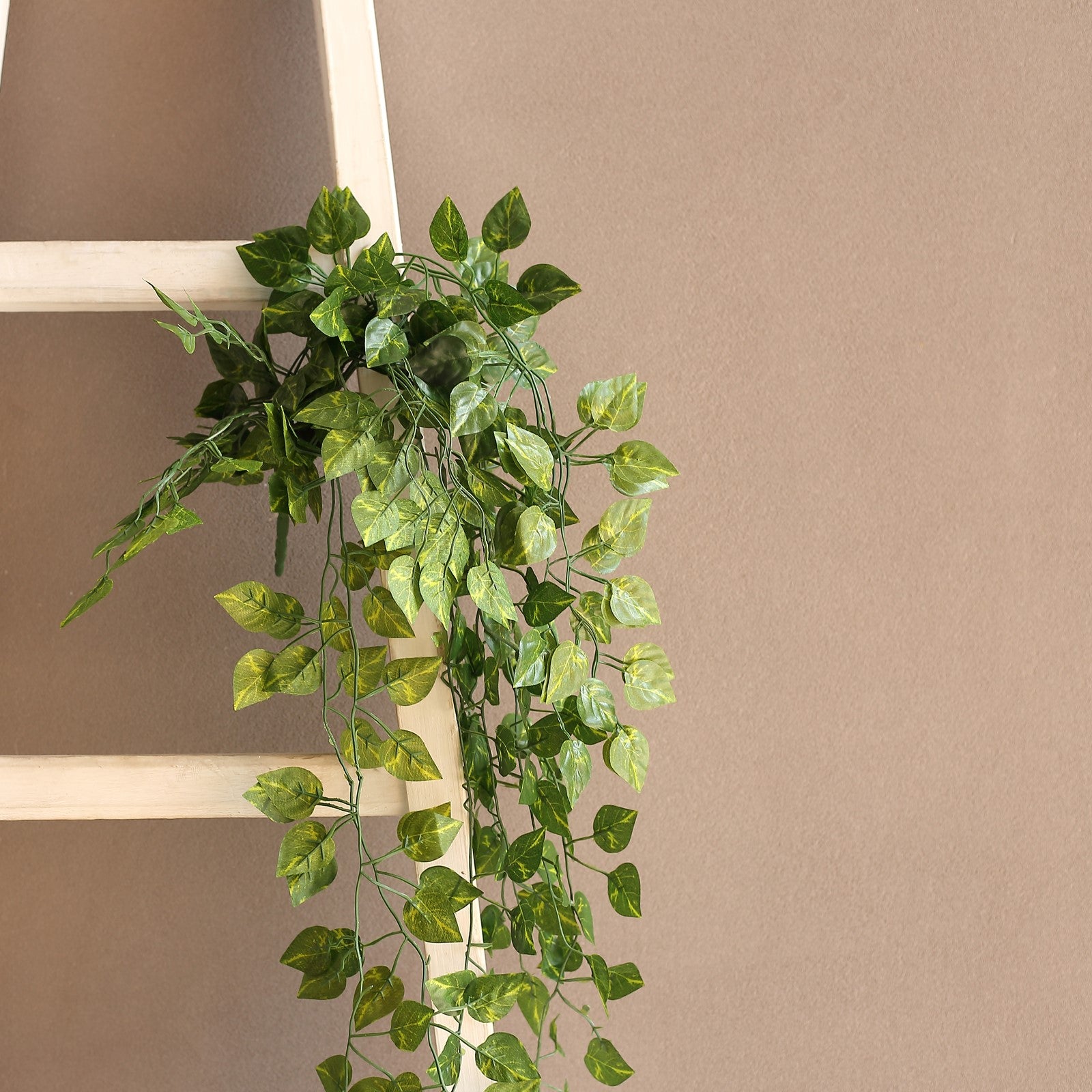 4 Pack Green Pothos Artificial Ivy Vine Hanging Plants on a ladder.