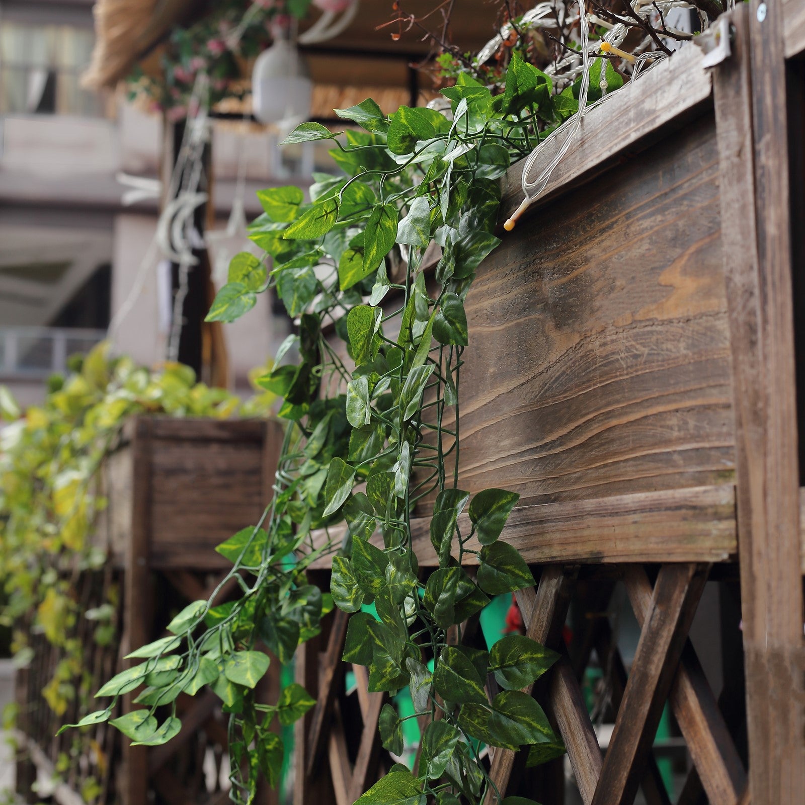 Green pothos artificial ivy vine hanging plants in a decorative planter.