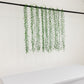 Green artificial hanging vines with weeping willow leaves for wall decor.