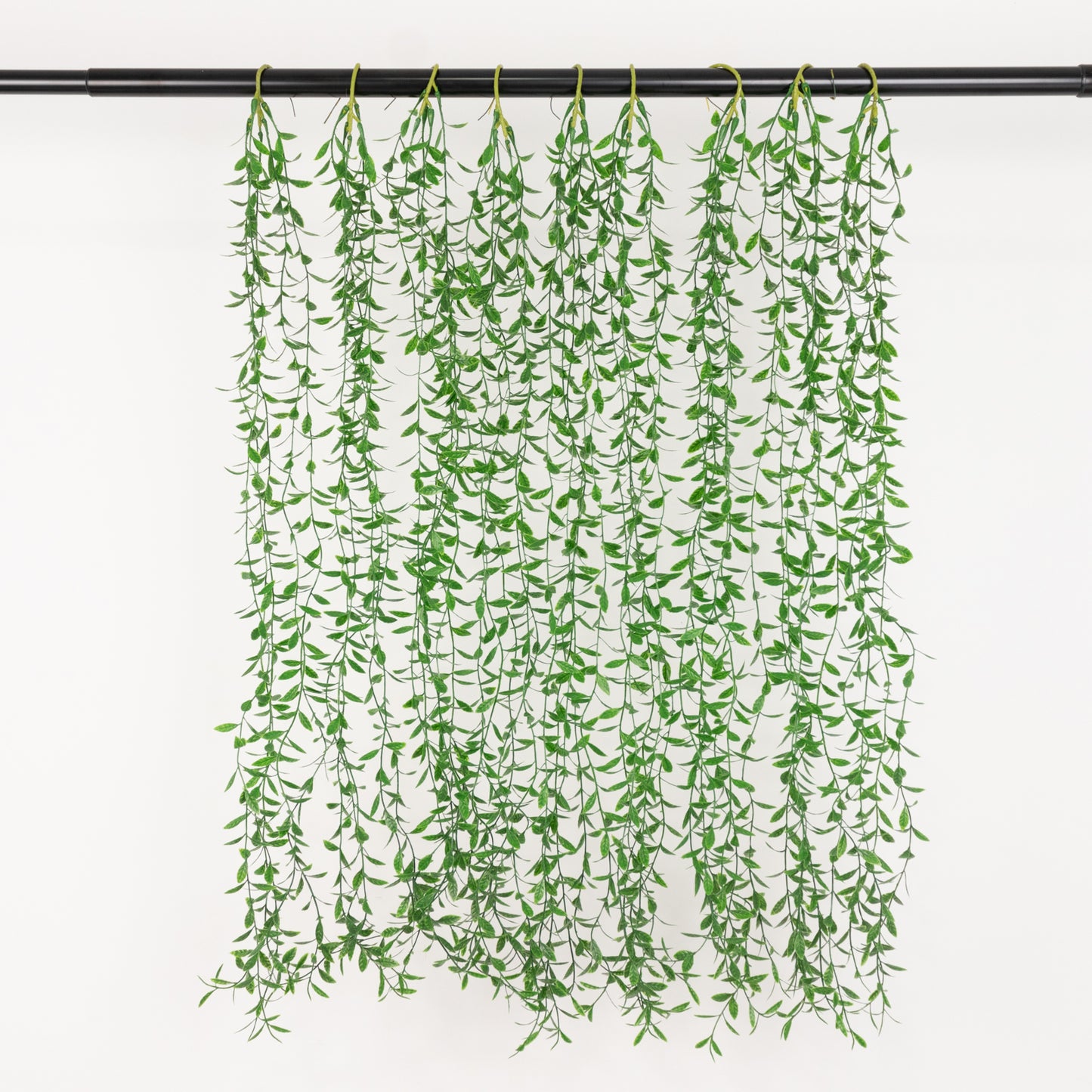 Green artificial hanging vines with weeping willow leaves, perfect for backdrop decor.