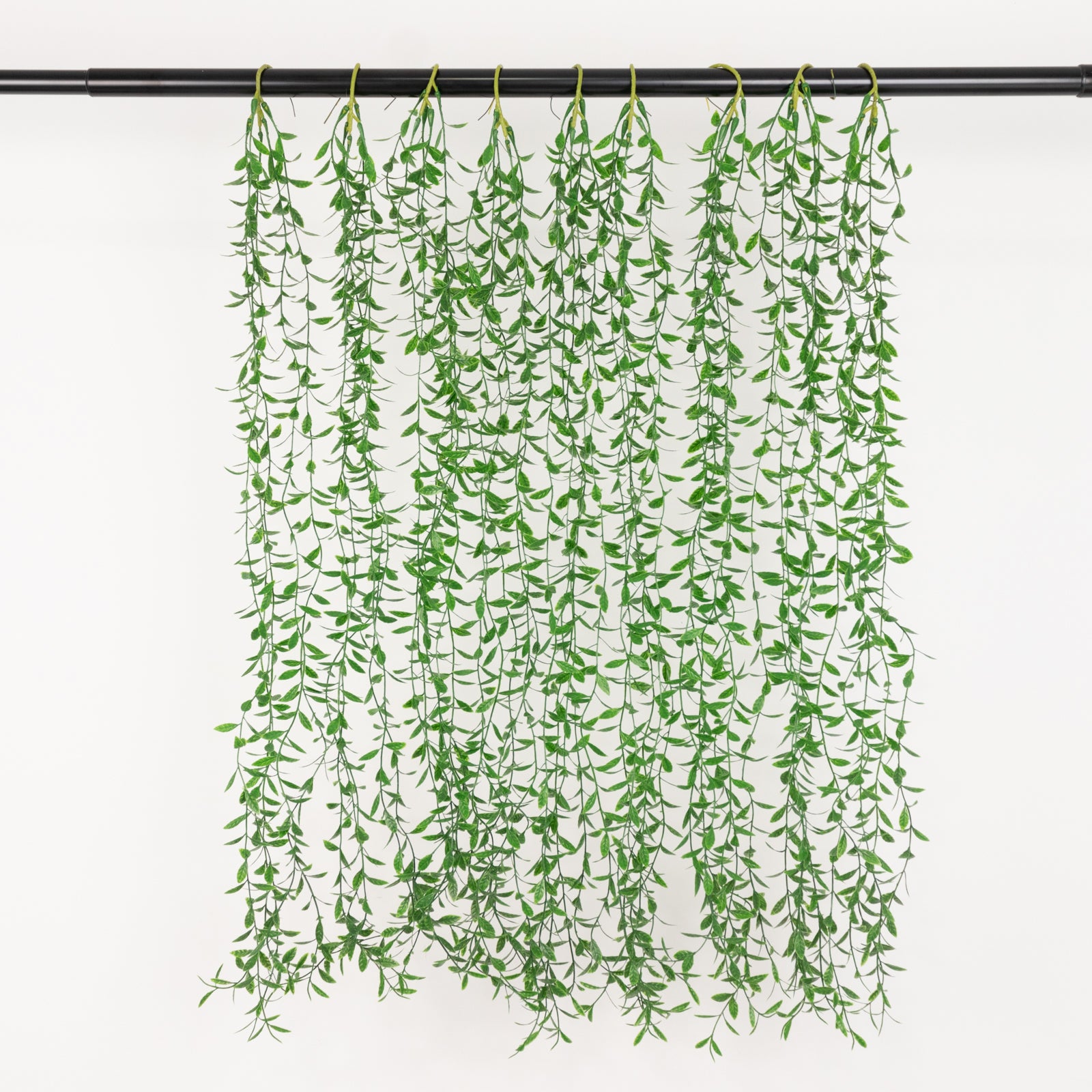 Green artificial hanging vines with weeping willow leaves, perfect for backdrop decor.
