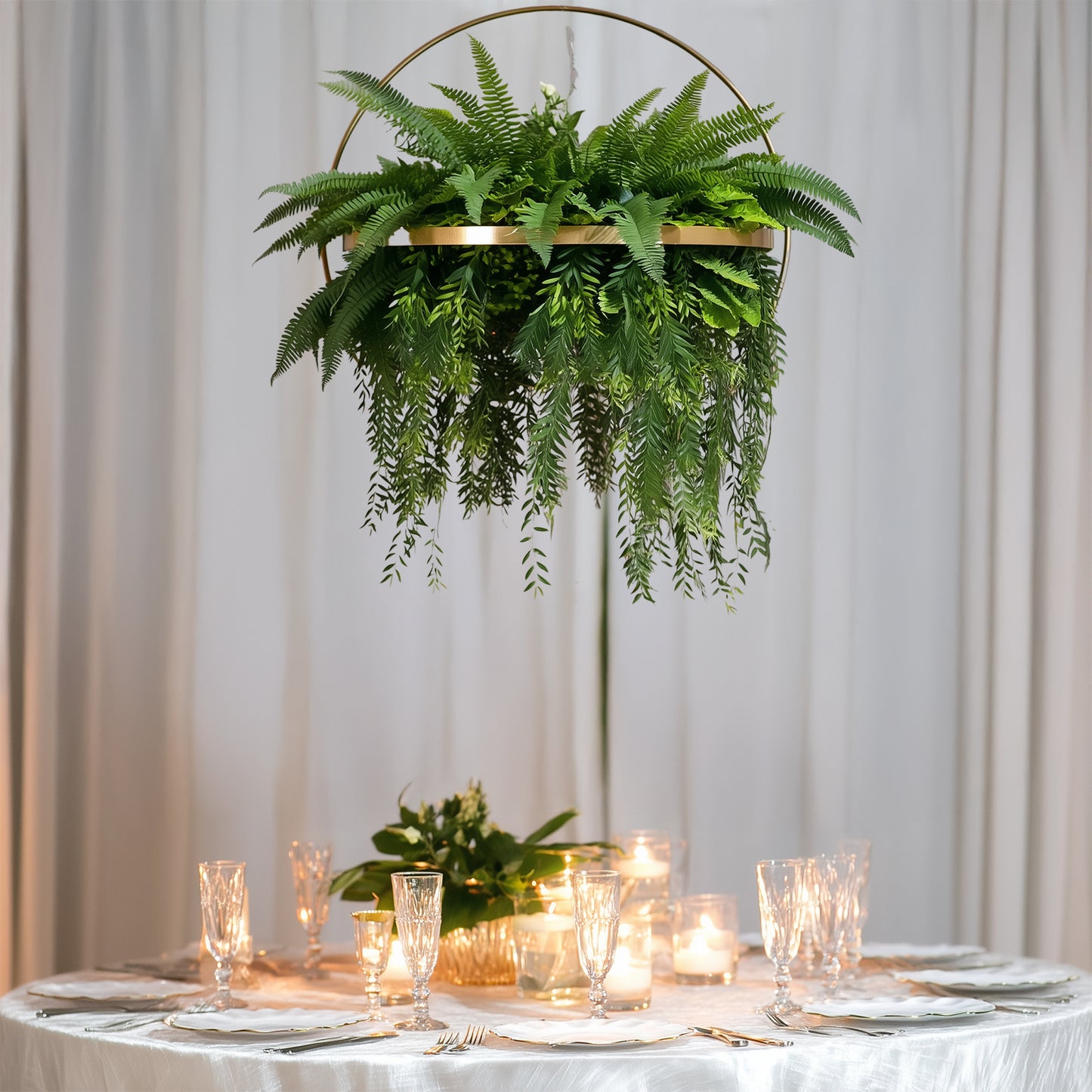 Large faux greenery hoop chandelier with gold ring and draping ferns.